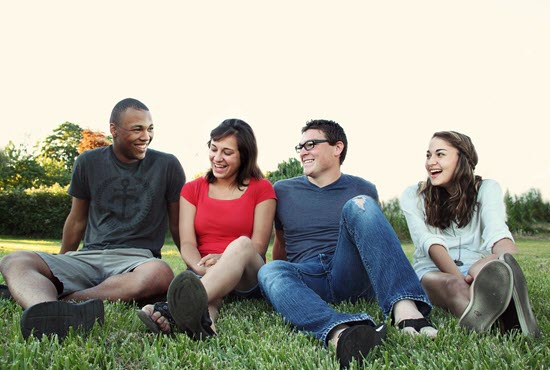 a group of people sitting and laughing in the park